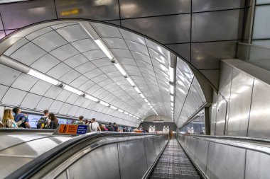Londra, UK- 19 Eylül 2024: Londra Yeraltı yürüyen merdiven modern eğimli çatı platforma iniyor.