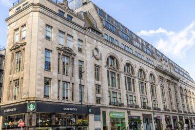 Londra, UK- 19 Eylül 2024: Oxford Caddesi 'nde büyük taş bina, altında Starbucks ve üzerinde kemerli pencereler.