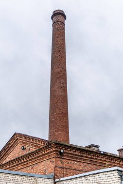 Liepaja, Letonya - 13 Haziran 2024: Kırmızı tuğla Karosta Su Kulesi ve uzun baca.