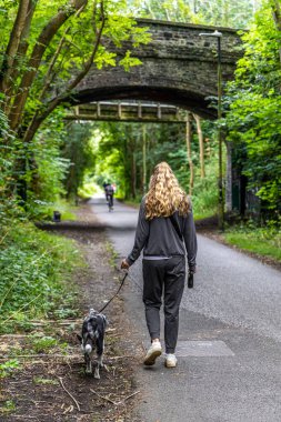 Bristol, İngiltere - 24 Temmuz 2024: Bristol eski demiryolu hattında köpeği gezdiren genç kadınlar şimdi Bristol 'dan Bath Cycle Yolu' na dönüştüler.