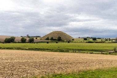 Silbury Hill, Avebury yakınlarında, Wiltshire, İngiltere. Avrupa 'nın en büyük yapay neolitik höyüğü olup, yeni bir Beaker People dalgası tarafından M.Ö. 2400 civarında yapılmıştır. 5 dönüm ve 40 metre yüksekliğinde..