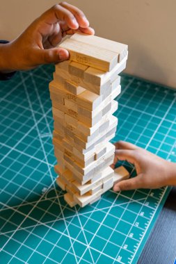 Bath, UK- 5 Ekim 2024: Jenga Oyununda Gergin Bir Oyuncu Bir Bloğu Dikkatle Kaldırırken.