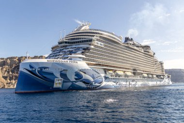 Santorini, Yunanistan - 20 Ekim 2024: Majestic Norveçli Prima Cruise gemisi Santorini 'nin engebeli uçurumlarını geçiyor.