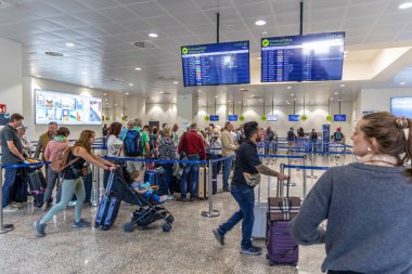 Santorini, Yunanistan - 21 Ekim 2024: Santorini Havaalanı 'nda kuyrukta bekleyen yolcular. Dijital ekranları ve giriş alanı olan modern terminal