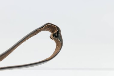 Zarar görmüş, kıvrık kenarlı, yırtık bir deri kemerin ayrıntılı görüntüsü..