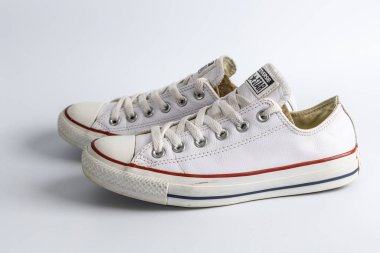 Bristol, UK- 30 Aralık 2024: Lastik tabanda kırmızı ve mavi çizgili çift beyaz Converse All Star spor ayakkabısı.