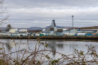 Glasgow, UK- 30 Mart 2024: Glasgow tersanesinde inşaat halindeki donanma gemisi nehir boyunca iskele ve vinçlerle