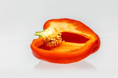 Yarım olgun kırmızı biber, beyaz bir arka planda izole edilmiş..