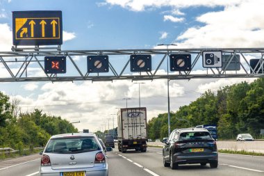 Bristol, İngiltere - 12 Eylül 2024: Birden fazla trafik şeridine sahip yoğun bir otoyol, üzerinde trafik ışıkları ve işaretleri bulunan bir gantry.