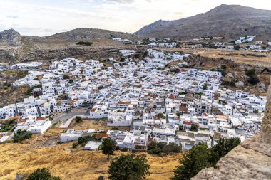 Rodos, Yunanistan - 9 Mayıs 2024: Yunanistan 'ın Rodos adasındaki bir turizm merkezi olan Lindos kasabasındaki beyazlatılmış evler ve bungalovlara genel bakış.