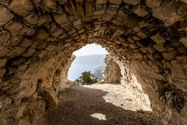 Monolithos Kalesi. 15. yüzyıldan kalma bir şatonun kalıntıları, deniz manzaralı bir uçurum üzerine inşa edilmiş..