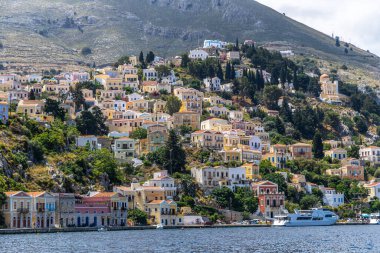 Symi, Yunanistan - 10 Mayıs 2024: Suriye adasındaki renkli evler köyü, Dodecanese Adası, Yunanistan.