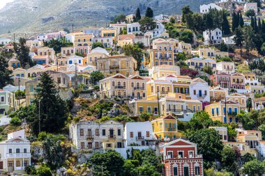 Symi, Yunanistan - 10 Mayıs 2024: Suriye adasındaki renkli evler köyü, Dodecanese Adası, Yunanistan.