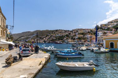 Symi, Yunanistan - 10 Mayıs 2024: Suriye adasındaki küçük tekne ve renkli evler.