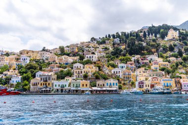 Symi, Yunanistan - 10 Mayıs 2024: Suriye adasındaki renkli evler köyü, Dodecanese Adası, Yunanistan.
