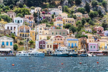 Symi, Yunanistan - 10 Mayıs 2024: Suriye adasındaki renkli evler köyü, Dodecanese Adası, Yunanistan.