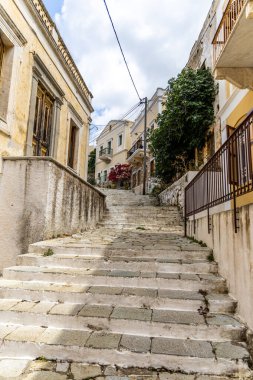 Symi, Yunanistan - 10 Mayıs 2024: Symi, Yunanistan 'da Bitkilerle Evler ve Çiçekler Arasındaki Adımlar.