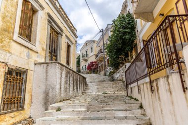 Symi, Yunanistan - 10 Mayıs 2024: Symi, Yunanistan 'da Bitkilerle Evler ve Çiçekler Arasındaki Adımlar.