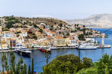 Symi, Yunanistan - 10 Mayıs 2024: Suriye adasındaki renkli evler köyü, Dodecanese Adası, Yunanistan.