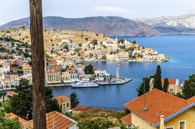 Symi, Yunanistan - 10 Mayıs 2024: Suriye adasındaki renkli evler köyü, Dodecanese Adası, Yunanistan.