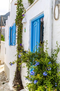 Pencereler, kapılar, Simi Adası 'ndaki eski evlerin balkonları. Yunanistan, Ege Denizi 'ndeki Rodos adalarından tatil yapıyor. Symi Körfezi 'ndeki renkli neoklasik evler. Tatil seyahat arkaplanı.