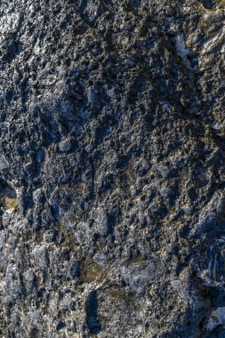 Samaria Gorge plajının sonundaki kayalık dokunun yakın çekimi, doğal kıyı manzarasını ve engebeli araziyi gösteriyor.