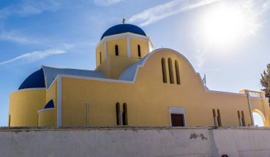 Oia 'daki Agios Georgios Kilisesi. Sarı Cephe ve Ege Denizi' ne bakan Mavi Kubbe..