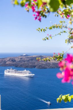 Santorini, Yunanistan - 15 Ekim 2024: Santorini 'nin Panoramik Deniz Burnu: Sakin Mavi Suları ve Engebeli Volkanı Geçen Bir Gemi Gemisi.