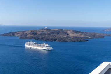 Santorini, Yunanistan - 15 Ekim 2024: Santorini 'nin Serene Seascape' si: Volkanik Adalar Yakınındaki Bir Gemi Gemisi.