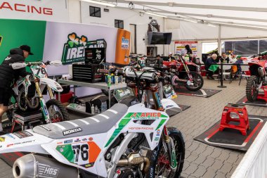 Winchester, UK- 5 Ekim 2024: 76 numaralı Honda Yarışı, aydınlık bir garajda off-road hareketine hazır..
