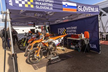 Winchester, UK- 5 Ekim 2024: Slovenya Moto Spor çadırı yoğun bir motokros etkinliğinde parlak turuncu motorlar sergiliyor.
