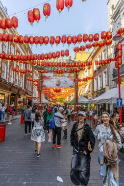 Londra, UK- 19 Eylül 2024: Canlı Londra Çin Mahallesi sokak sahnesi kırmızı fenerler, hareketli insanlar ve kültür dükkanları.