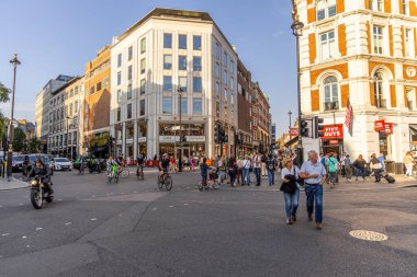 Londra, UK- 19 Eylül 2024: Canlı Londra kavşağında insanlar sergileniyor, modern dükkanlar.