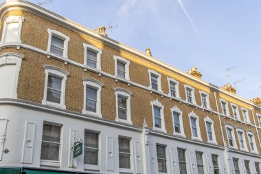 Londra, UK- 19 Eylül 2024: Tuğla duvarlı ve dekoratif beyaz pencere çerçeveli Londra konağı.