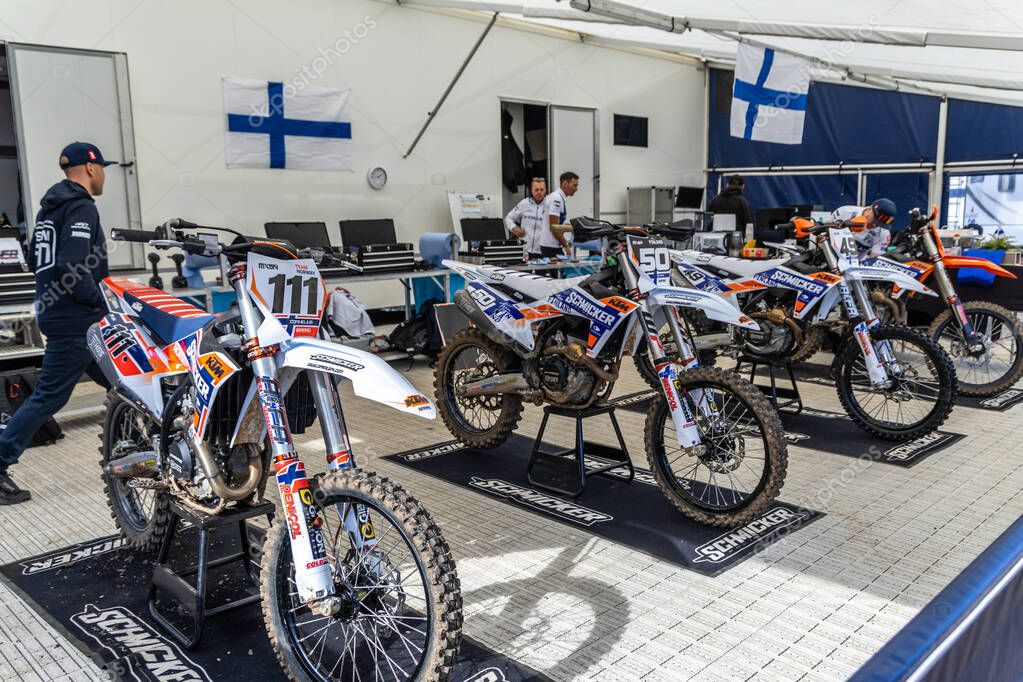 Winchester, UK- October 5, 2024: Finnish motocross pit with numbered bikes 111 and 50 prepped under team tent.