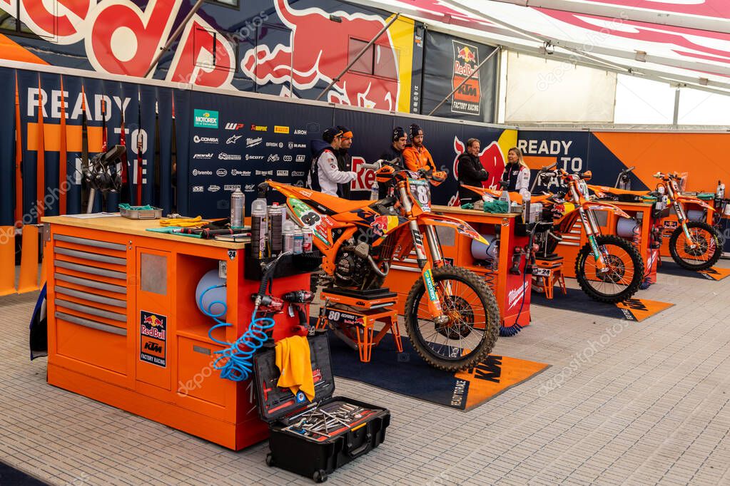 Winchester, UK- October 5, 2024: KTM factory pit area with bright orange bikes and gear in a race day setup.