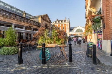 Londra, UK- 19 Eylül 2024: Londra 'daki Covent Garden' ın kaldırım taşı caddeleri kalabalık dükkanlar ve yayalar ile büyüleyici, kentsel seyahat ve mimari için mükemmel.
