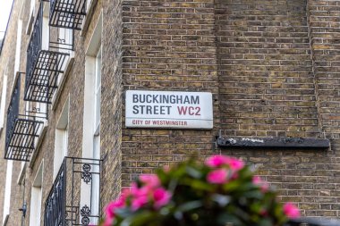 Londra, UK- 19 Eylül 2024: Klasik Londra Tabelası: Buckingham Street 'in Brickwork ve Vibrant Blooms Westminster' da.