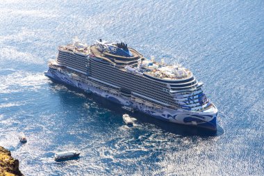 Santorini, Yunanistan - 15 Ekim 2024: Yunanistan 'da güneşli bir yaz gününde Santorini kalderası yakınlarında demirlemiş Norveç Viva yolcu gemisi.