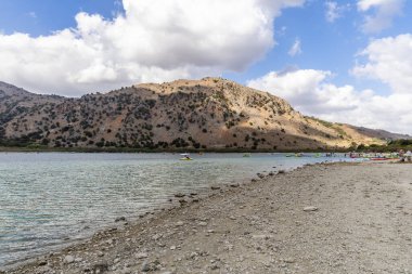 Heraklion, Yunanistan - 17 Ekim 2024: Kournas Gölü 'nde Eğlence Cenneti: Kayak ve Su Aktiviteleri Rocky Peyzajına Karşı.
