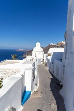 Santorini, Yunanistan - 15 Ekim 2024: Santorini 'nin Serene Paths of Santorini: Denize Bakan Tenha Bir Kiliseye Giden Dar Bir Sokak.