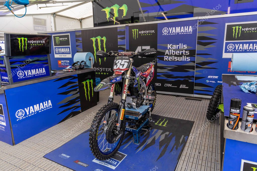 Winchester, UK- October 5, 2024: Monster Energy Yamaha pit showcasing Karlis Alberts Reisulis bikes and bold sponsor displays.