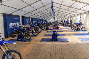 Winchester, UK- 5 Ekim 2024: Büyük bir tepe örtüsü altında Yamaha motokros makinelerinin bulunduğu geniş çayırlık alan.