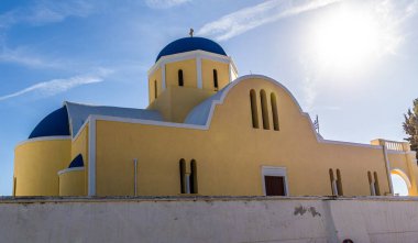 Oia 'daki Agios Georgios Kilisesi. Sarı Cephe ve Ege Denizi' ne bakan Mavi Kubbe..