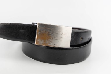 Üzerinde büyük çizikler olan siyah kuşak. Gerçek ya da sahte deri tokalı. Modern minimalist..