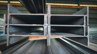 Çelik kiriş üretimi. Metal profil kirişi, metal üretimleri ambarında ambalajlar halinde çeliktir. Metal yapıların üretimi için fabrikanın ürünleri. Kaynak I-ışını
