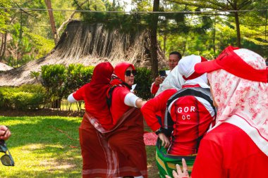 Endonezyalı bir grup kadın, zaferi Endonezya 'nın 1 Eylül 2023 tarihli bağımsızlık gününde ellerinde bayraklarla kutluyor.