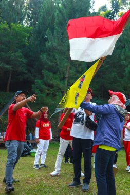 Endonezyalı bir grup kadın, zaferi Endonezya 'nın 1 Eylül 2023 tarihli bağımsızlık gününde ellerinde bayraklarla kutluyor.