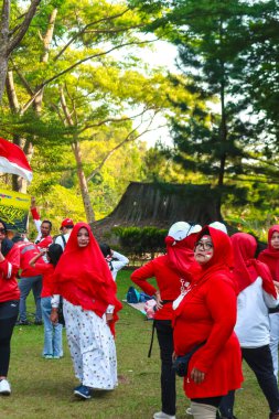 Endonezyalı kadınlar zaferi Endonezya 'nın bağımsızlık gününde bayrak sallayarak kutluyorlar.