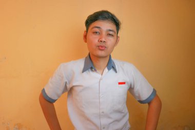 Endonezyalı erkek lise öğrencileri gri ve beyaz üniformalar giyerler. Sarı bir arkaplanda ve çok çeşitli ifadelerle izole edilmiş.